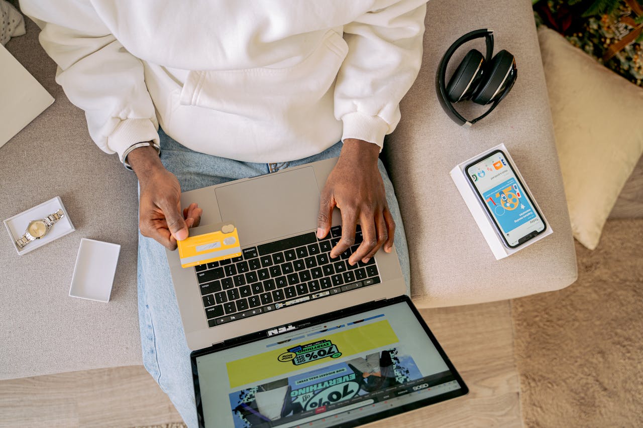 Person shopping online with a credit card on a laptop, emphasizing convenience and technology.